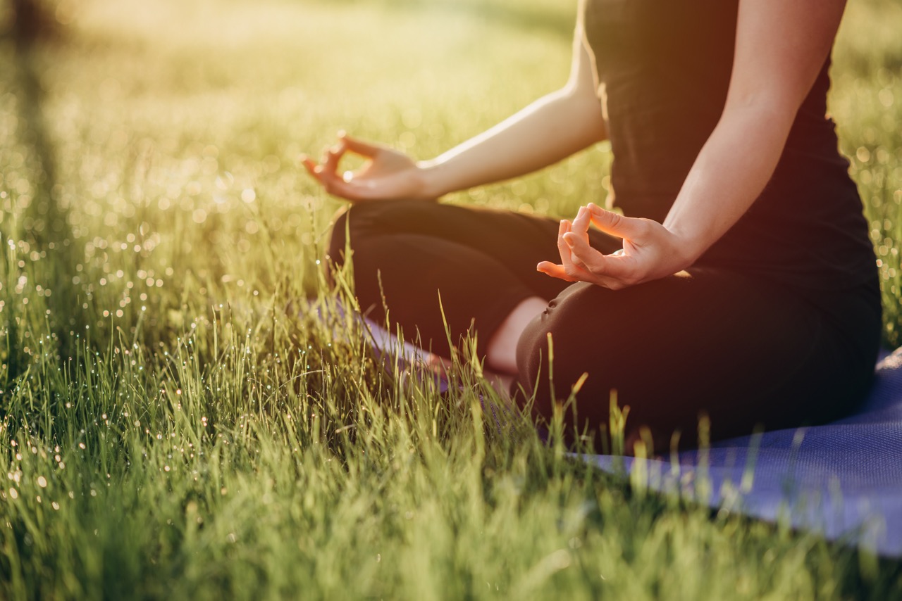 woman meditating on grass